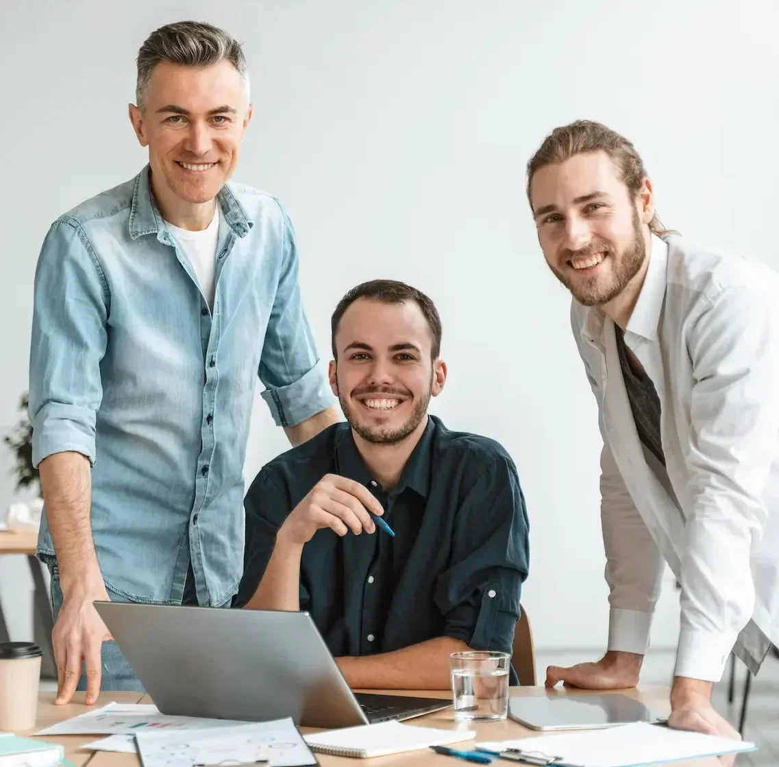 StaticMint creative team collaborating in office meeting around laptop